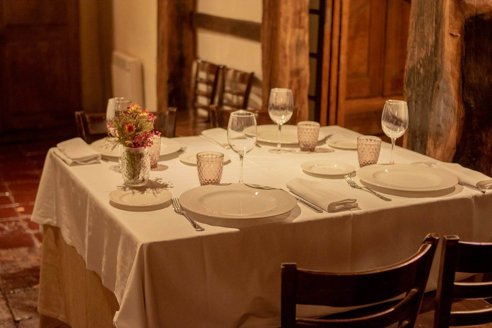A cozy home dining table set with elegant plates and candles, ready for a special date night.