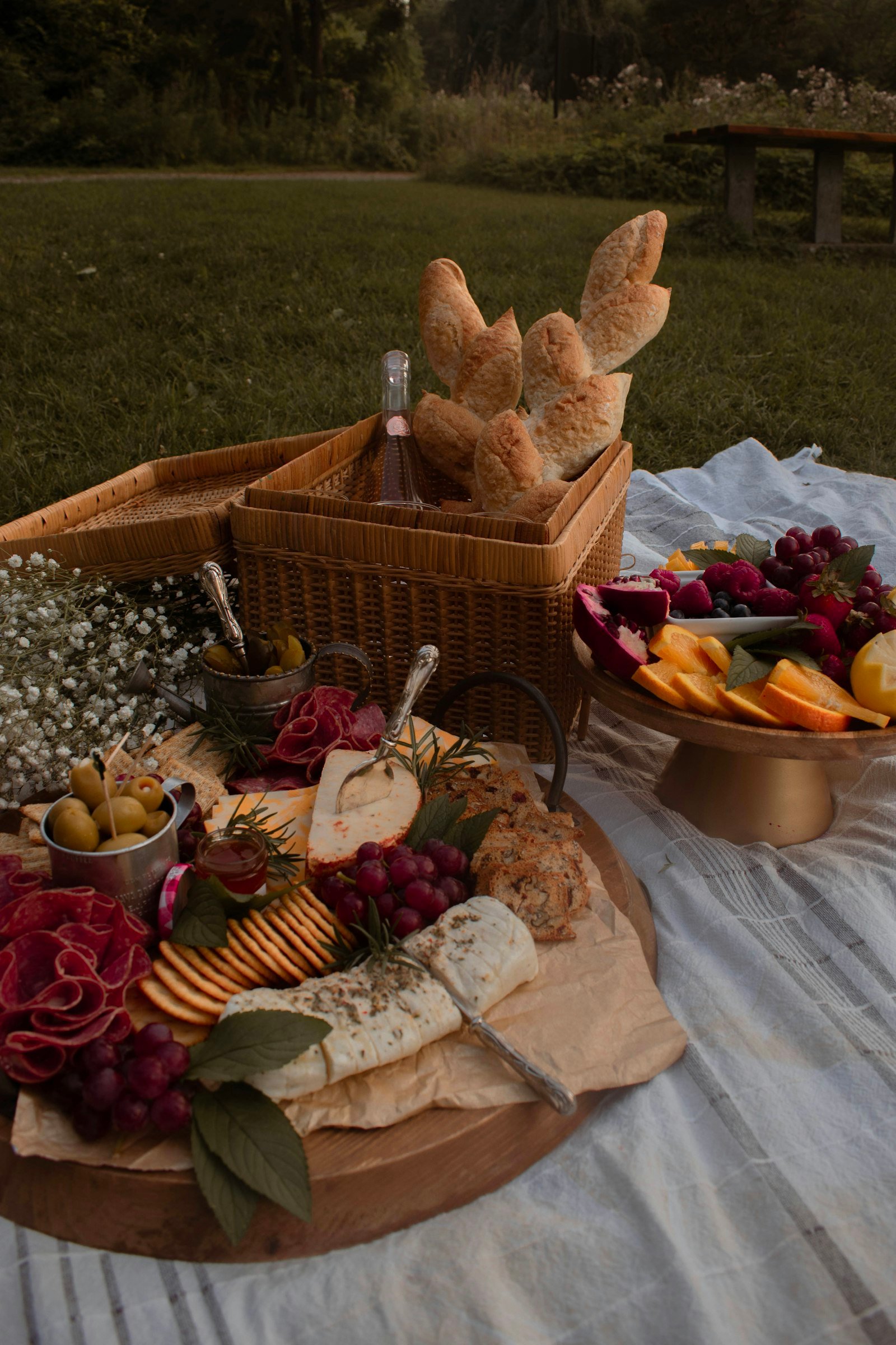 An outdoor picnic spread on a sunny day with fresh seasonal dishes artfully arranged on a rustic blanket.