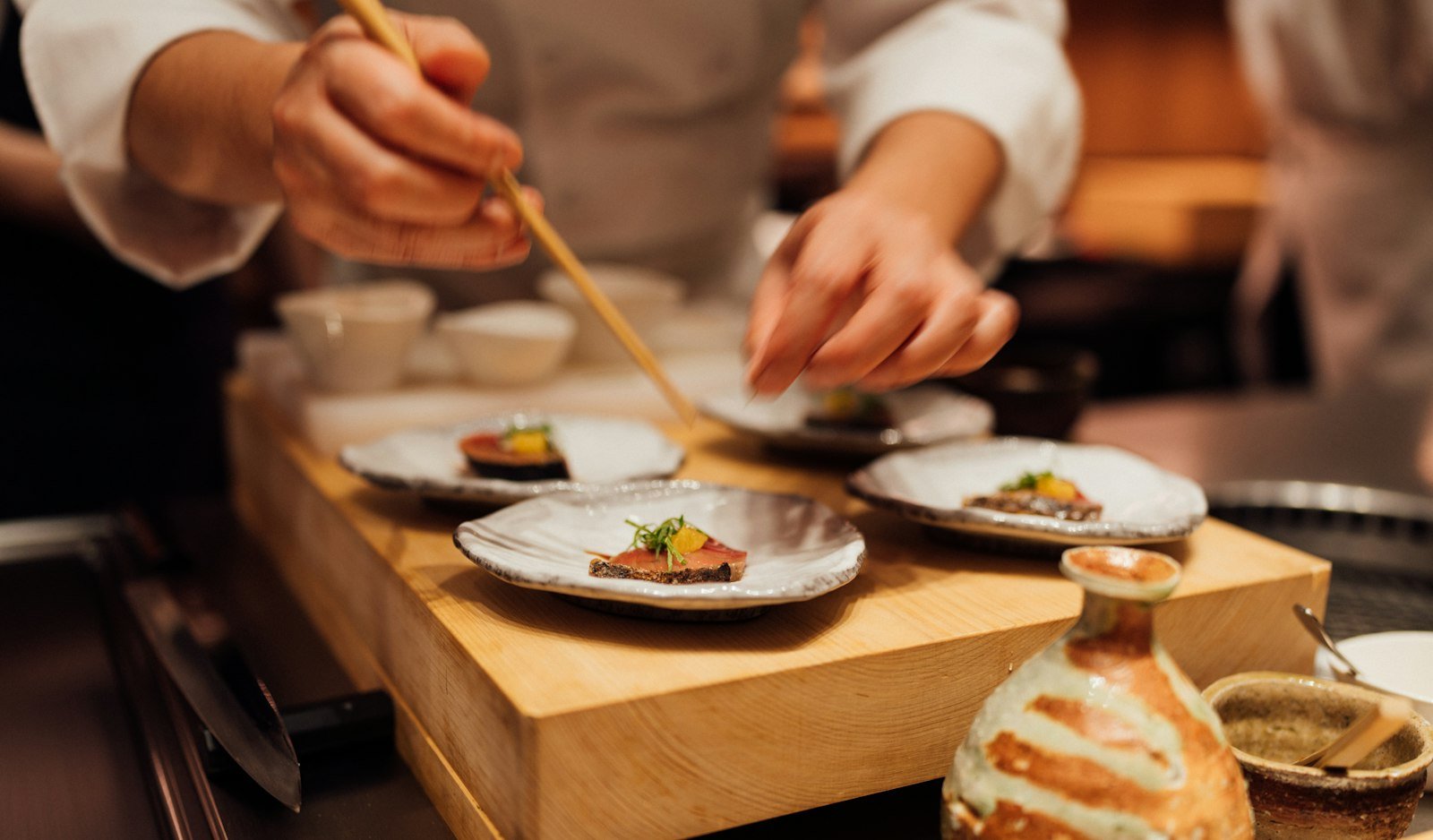A vibrant appetizer being plated in a warmly lit home kitchen.