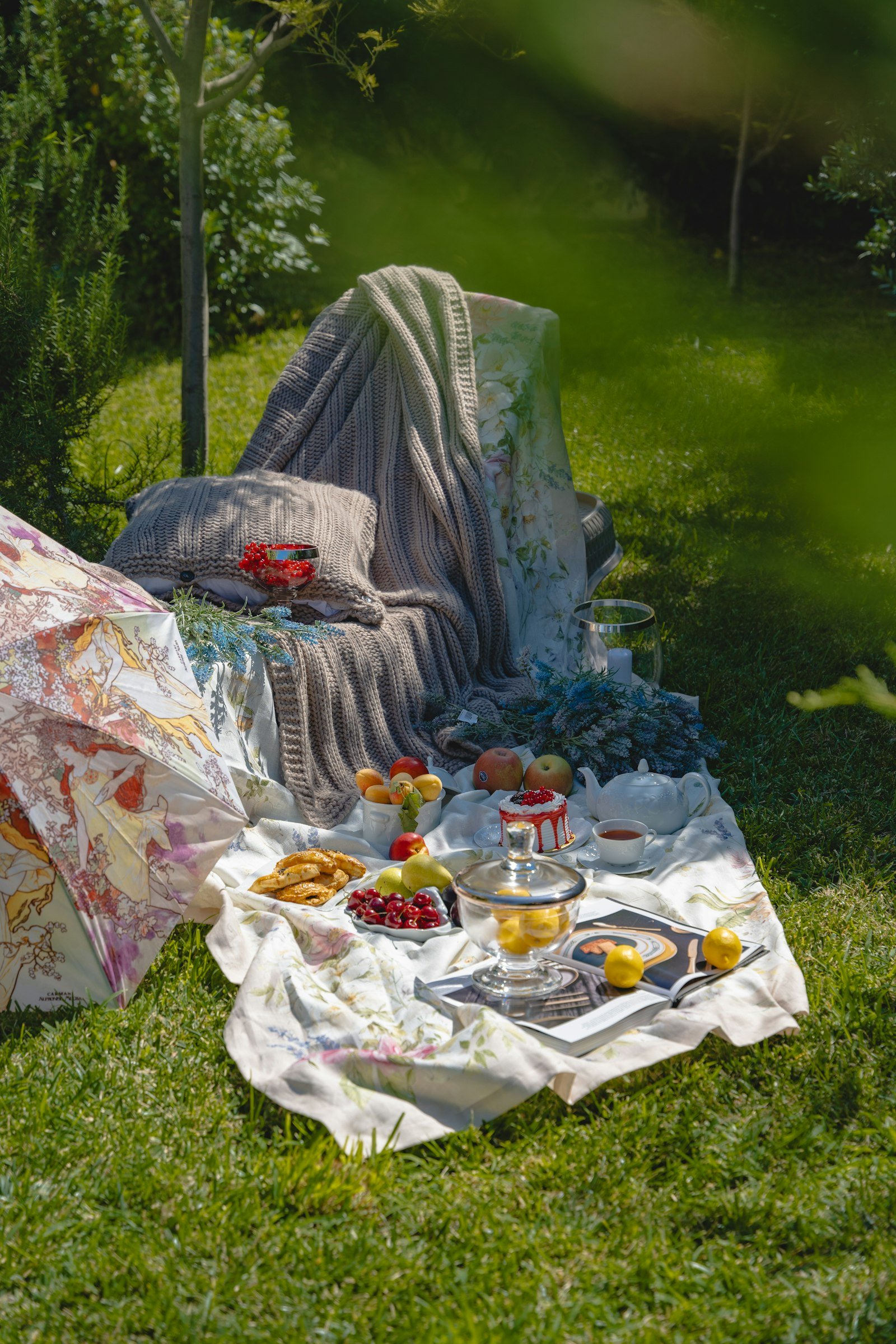 A sunlit picnic spread on a blanket in a lush garden, featuring colorful plates and fresh ingredients.