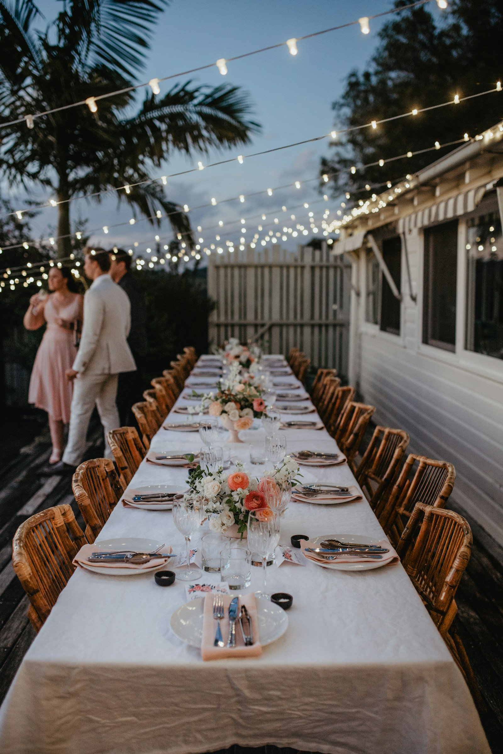 An elegant outdoor dinner under string lights.